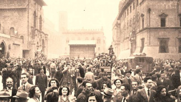 Folla di persone in piazza del Nettuno a Bologna il giorno della Liberazione