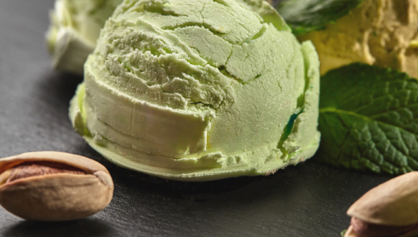 pallina di gelato al pistacchio  con a fianco due pistacchi