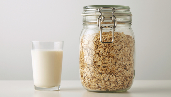 bicchiere di bevanda vegetale d'avena, vaso di vetro contenente fiocchi d'avena